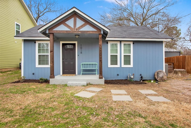 bungalow-style home with fence and a front yard