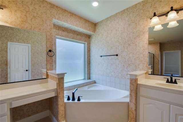 bathroom with wallpapered walls, a bath, and vanity