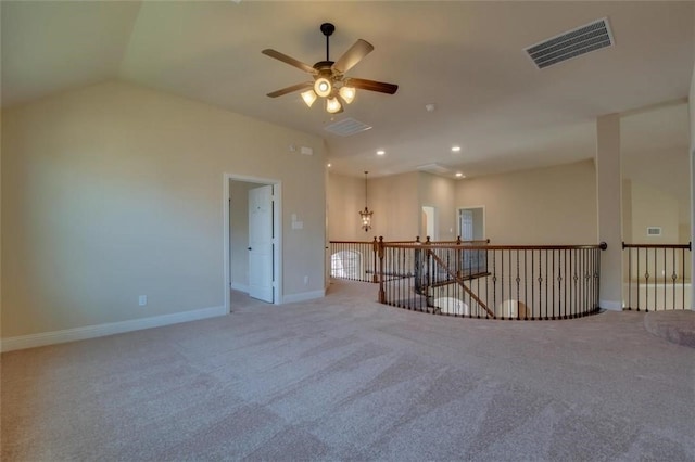 spare room with recessed lighting, light carpet, visible vents, baseboards, and vaulted ceiling