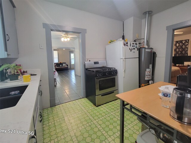 kitchen with light countertops, gas water heater, a ceiling fan, gas range, and freestanding refrigerator