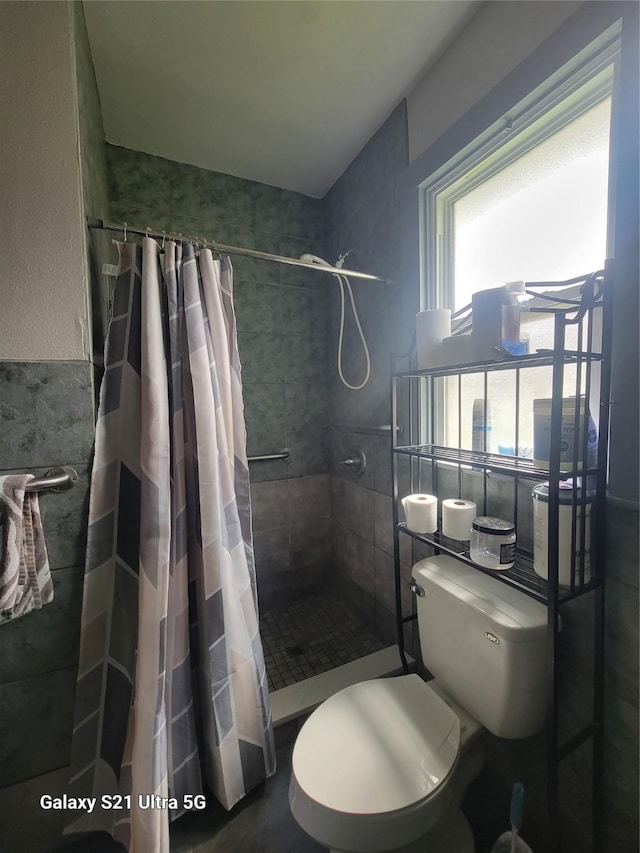 full bath with toilet and tiled shower
