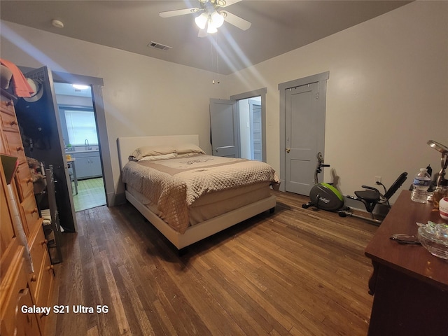 bedroom with a sink, visible vents, and dark wood finished floors