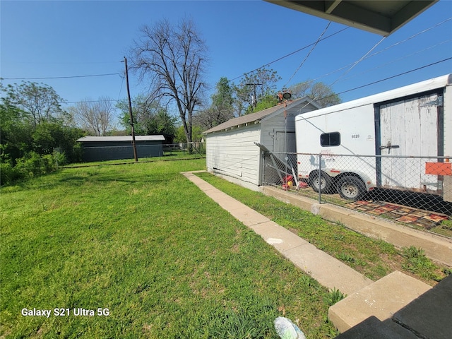 view of yard with an outdoor structure and fence