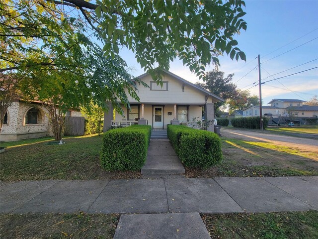 bungalow-style home with a front lawn and a porch