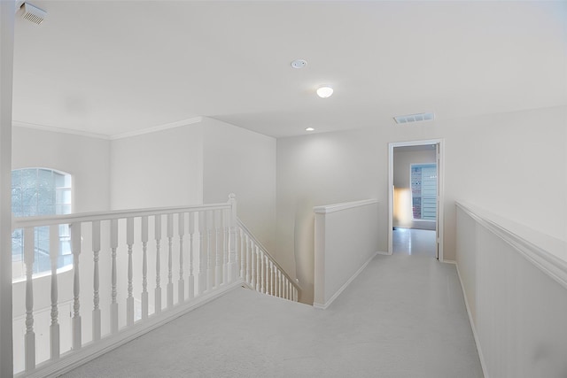 corridor with carpet, an upstairs landing, visible vents, and baseboards