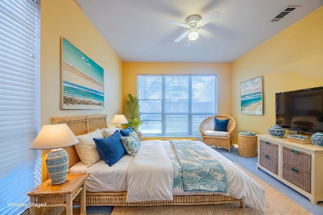 carpeted bedroom with a ceiling fan and visible vents