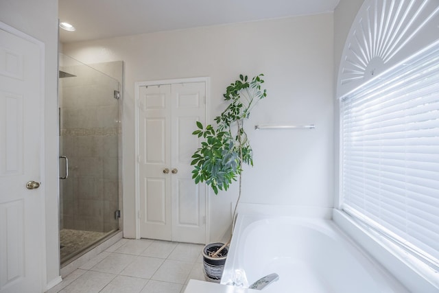 bathroom featuring tile patterned floors, a shower stall, and a bath