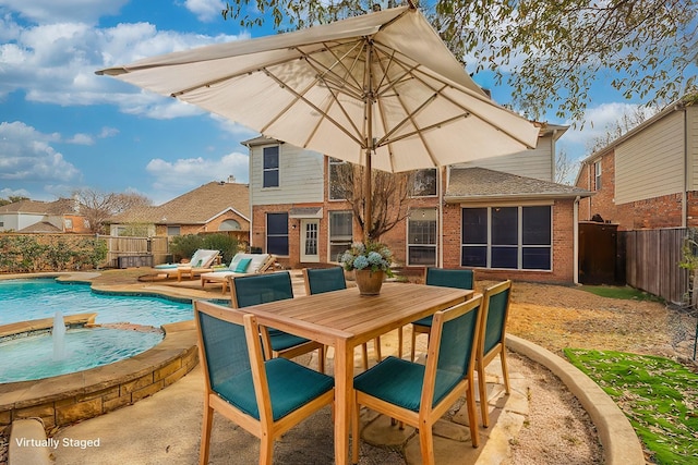 rear view of property with brick siding, a fenced in pool, outdoor dining area, a fenced backyard, and a patio area