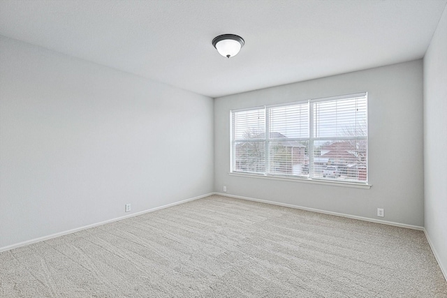 empty room with light carpet and baseboards