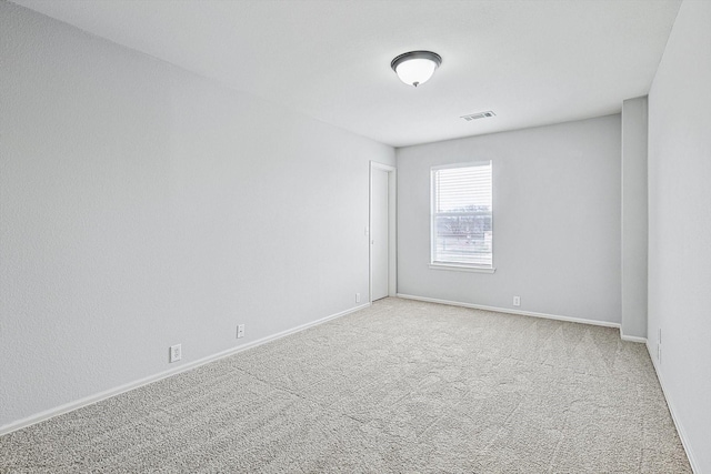 carpeted spare room with baseboards and visible vents