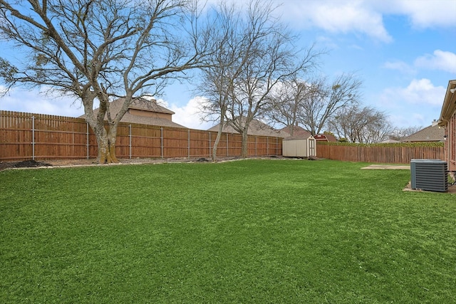 view of yard featuring a fenced backyard, an outdoor structure, central AC unit, and a shed