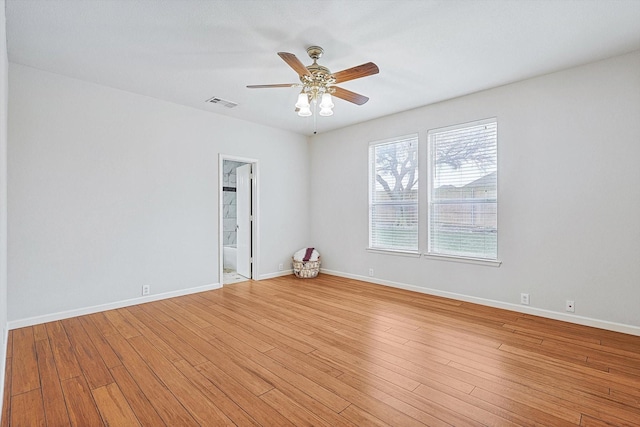 spare room with light wood finished floors, baseboards, and visible vents