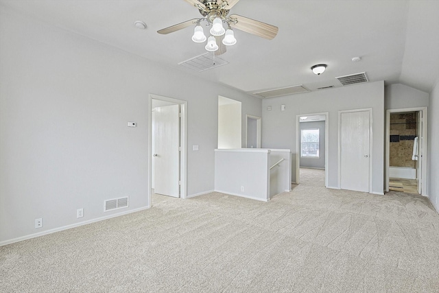 unfurnished room featuring light carpet, attic access, visible vents, and a ceiling fan