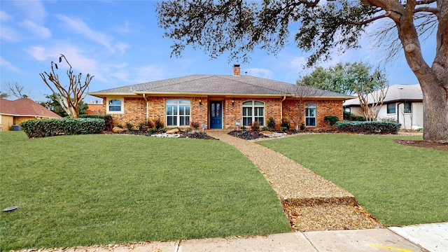 ranch-style house with brick siding, a chimney, and a front lawn