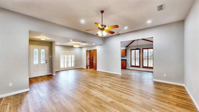 unfurnished living room featuring light wood-type flooring, visible vents, ceiling fan, and baseboards