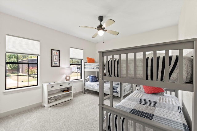 carpeted bedroom featuring multiple windows and baseboards