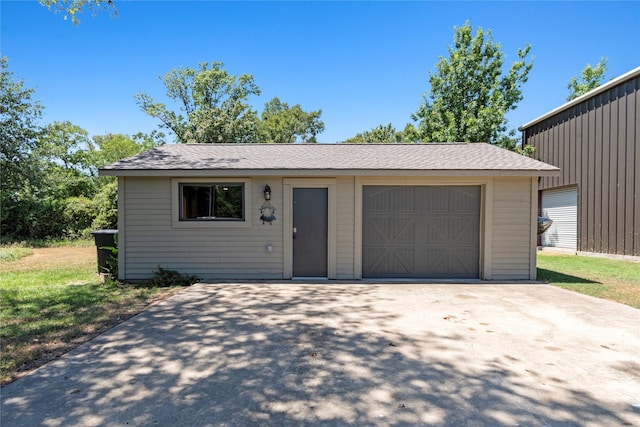 view of front of house featuring driveway, an outdoor structure, and a detached garage