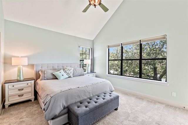 bedroom featuring baseboards, high vaulted ceiling, a ceiling fan, and light colored carpet