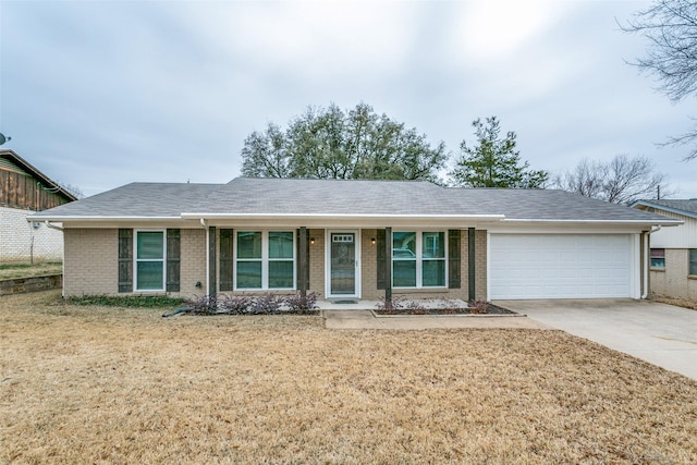 ranch-style house featuring driveway, brick siding, an attached garage, and a front yard