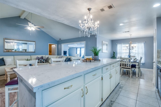 kitchen featuring visible vents, hanging light fixtures, open floor plan, white cabinets, and a kitchen island