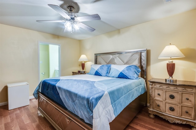 bedroom featuring dark wood-type flooring, connected bathroom, a ceiling fan, and baseboards