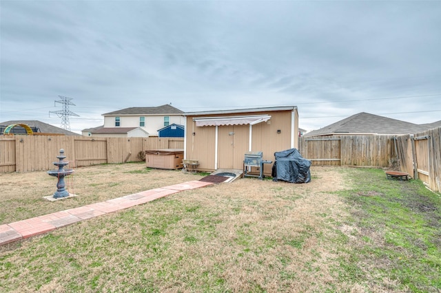 view of yard with a fenced backyard and a hot tub