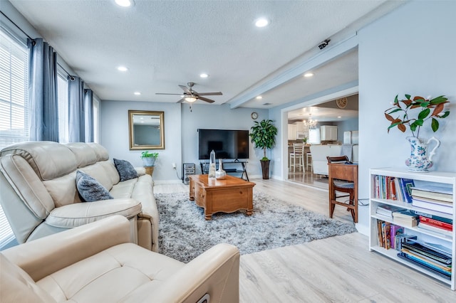 living area featuring light wood-style flooring, recessed lighting, a textured ceiling, and a ceiling fan