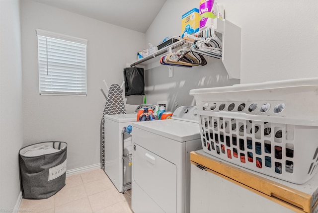 laundry area with light tile patterned floors, laundry area, washer and clothes dryer, and baseboards