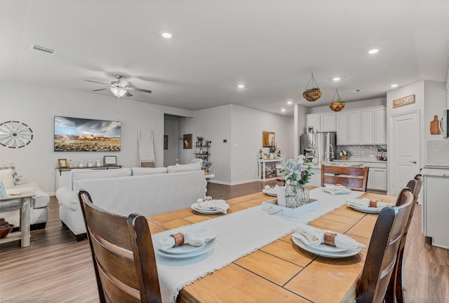 dining area featuring light wood finished floors, visible vents, and recessed lighting