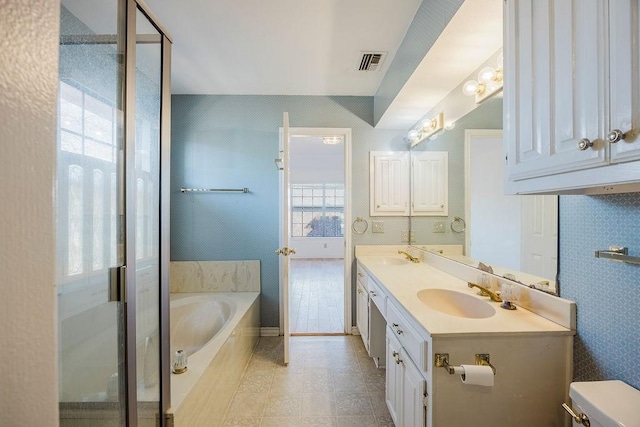 bathroom with a garden tub, a sink, visible vents, and double vanity