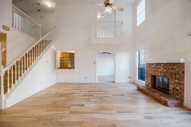 unfurnished living room featuring ceiling fan, plenty of natural light, and wood finished floors