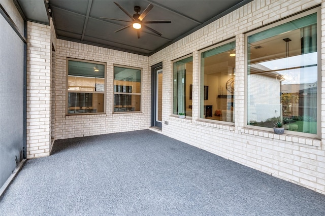 unfurnished sunroom featuring ceiling fan