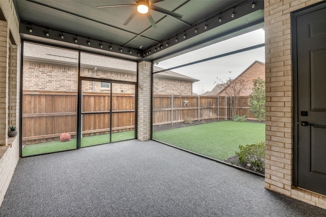 unfurnished sunroom with rail lighting and ceiling fan