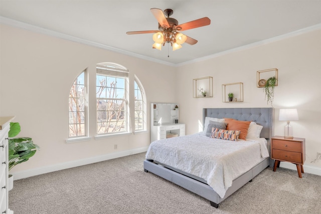 carpeted bedroom featuring ornamental molding, a ceiling fan, and baseboards