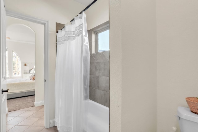 ensuite bathroom with ensuite bathroom, curtained shower, toilet, and tile patterned floors