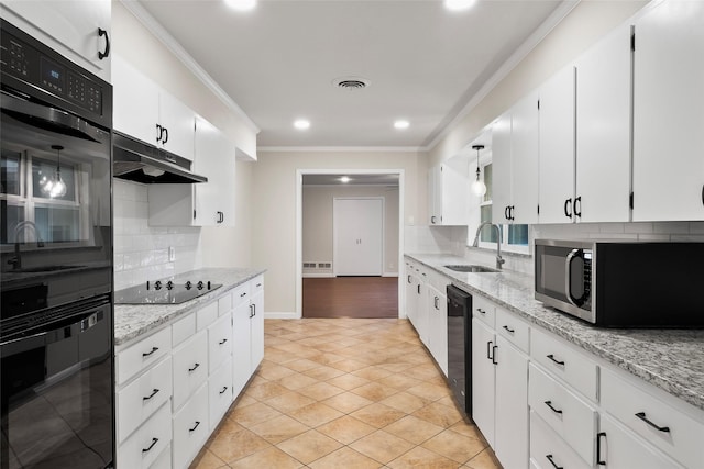 kitchen with white cabinetry, a sink, under cabinet range hood, and black appliances