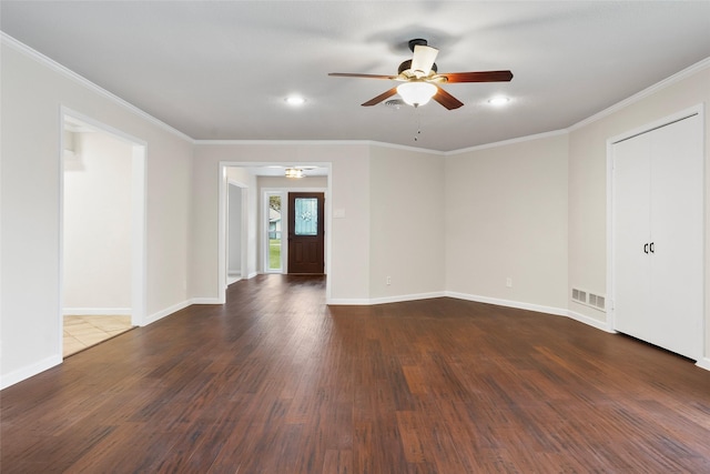 spare room with baseboards, crown molding, visible vents, and dark wood-style flooring