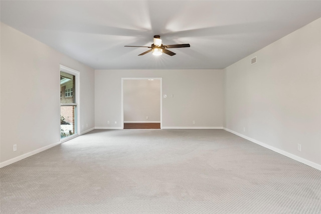 unfurnished room with ceiling fan, carpet floors, visible vents, and baseboards