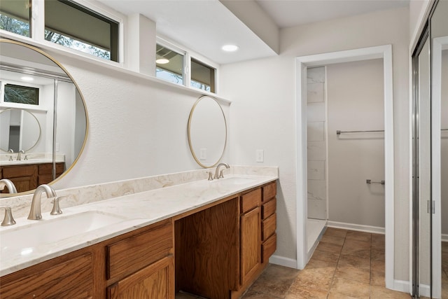 bathroom featuring double vanity, baseboards, and a sink