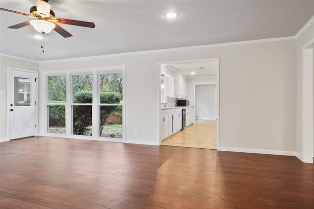 unfurnished living room with ornamental molding, baseboards, a sink, and light wood finished floors