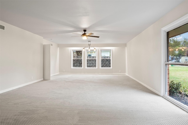 unfurnished room featuring a ceiling fan, light carpet, visible vents, and baseboards