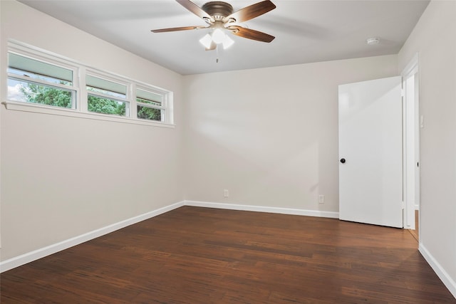 spare room featuring ceiling fan, baseboards, and dark wood-type flooring