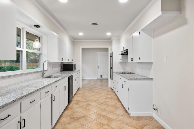 kitchen with under cabinet range hood, a sink, white cabinets, black appliances, and decorative light fixtures