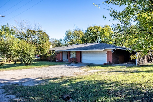 ranch-style home with a garage, driveway, brick siding, and a front lawn