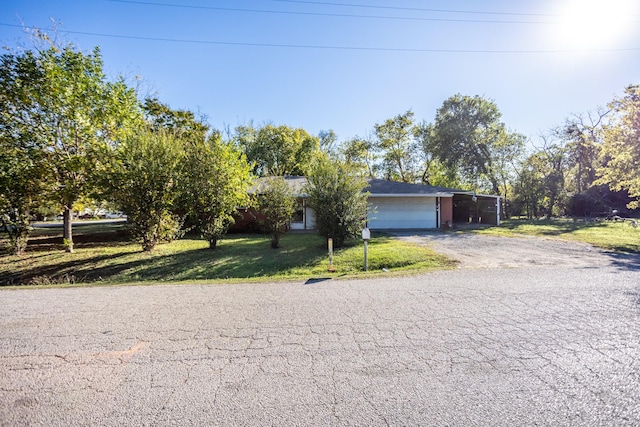 view of front of home with an attached garage, a front lawn, and aphalt driveway