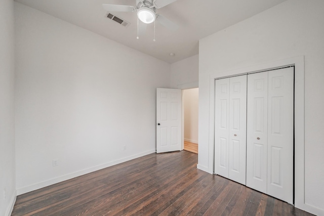unfurnished bedroom with a ceiling fan, visible vents, baseboards, a closet, and dark wood finished floors