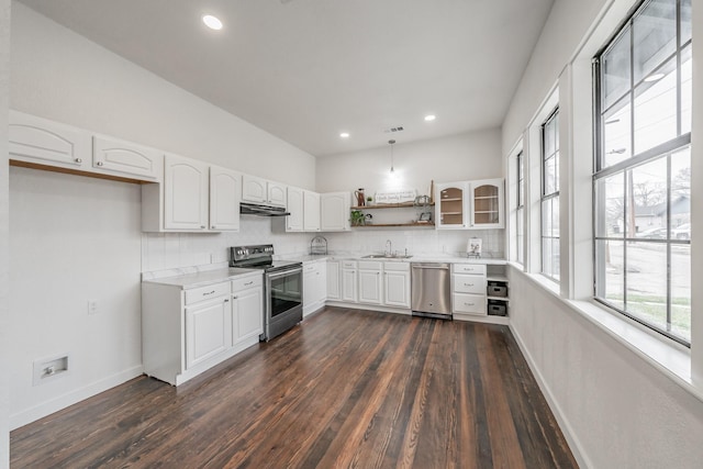 kitchen with stainless steel appliances, white cabinets, light countertops, open shelves, and glass insert cabinets