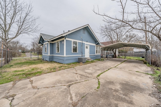 view of home's exterior with cooling unit, fence, concrete driveway, roof with shingles, and a detached carport
