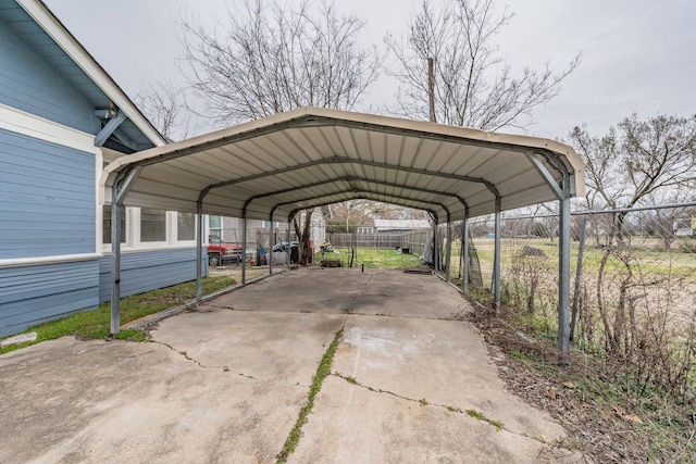 view of vehicle parking with fence and a detached carport