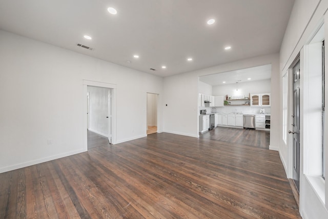 unfurnished living room with dark wood-style floors, recessed lighting, visible vents, and baseboards